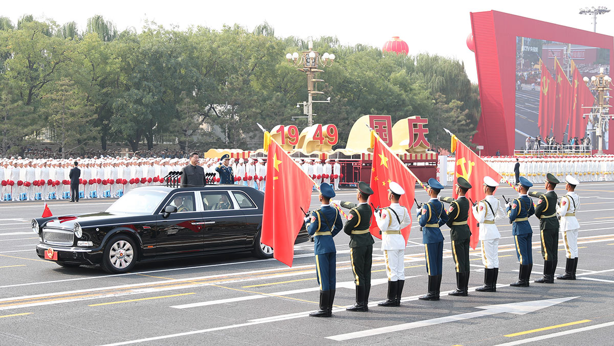 習(xí)近平驅(qū)車行進(jìn)至黨旗、國旗、軍旗前，向旗幟行注目禮